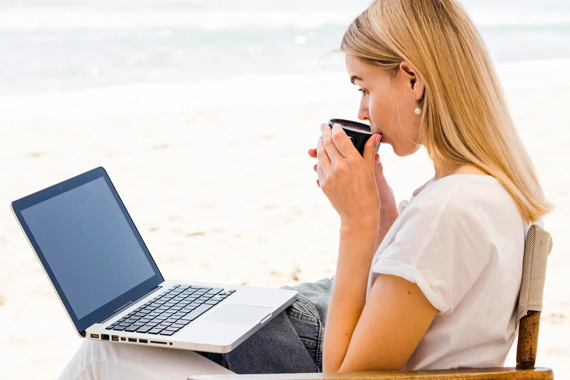 side-view-woman-beach-working-having-coffee